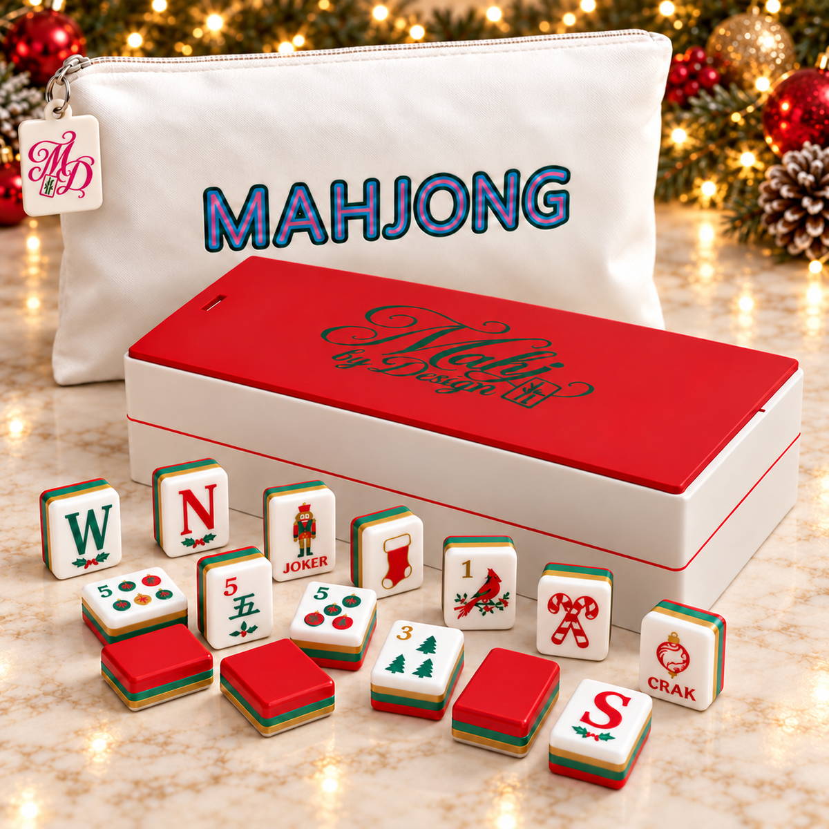 Christmas mahjong tile set with red-lidded box and tagged white bag, styled with evergreen, red and gold ornaments and warm Christmas lights. Digital product rendering.
